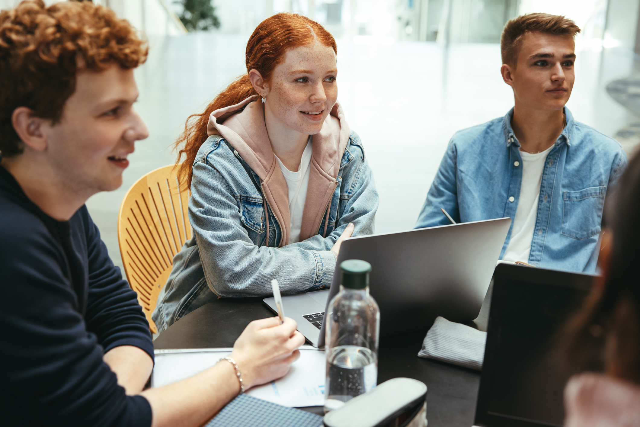 Grupp med skoleelever som jobbar på en skoluppgift tillsammans.