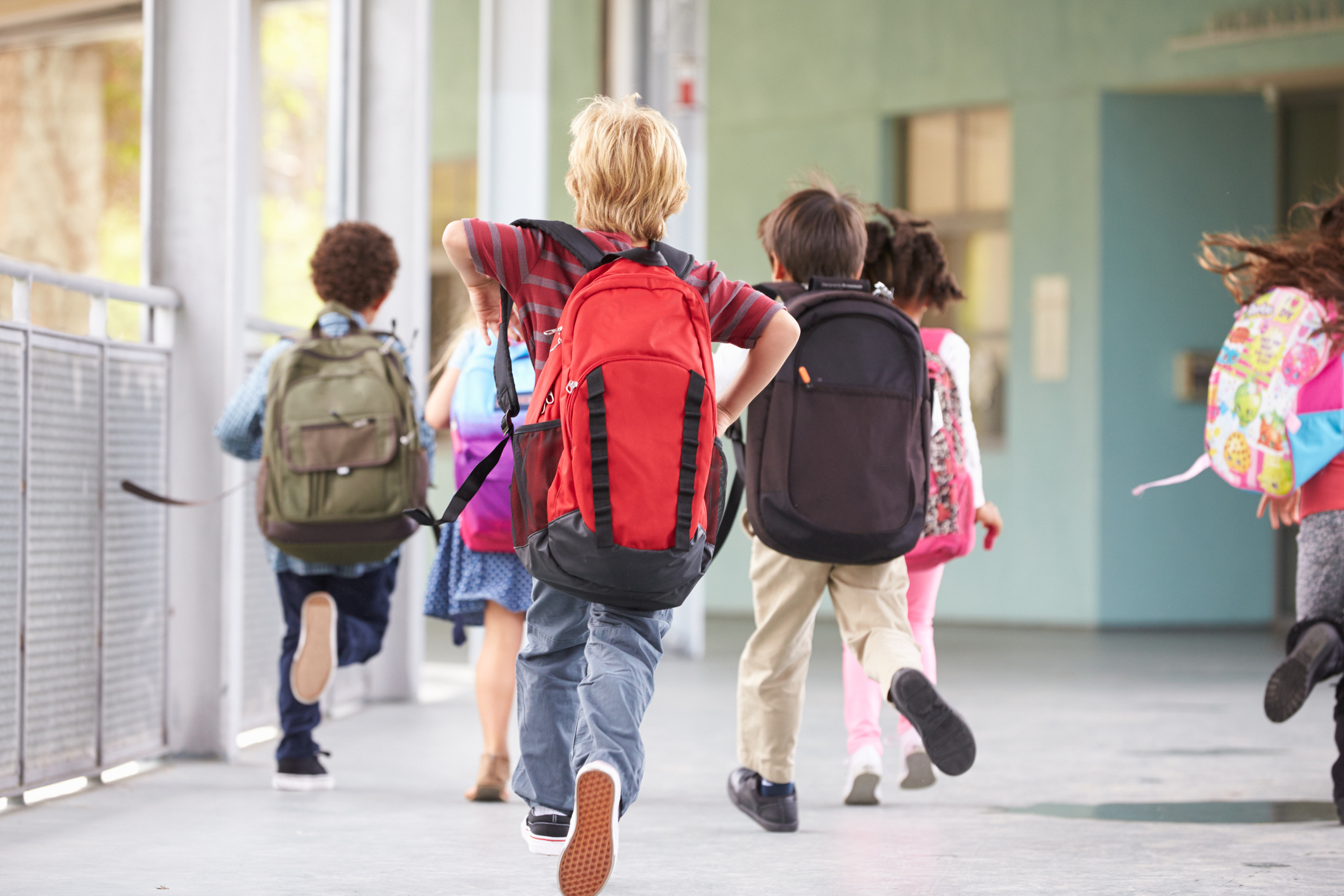 Grupp med grundskoleelever som springer på skolgården